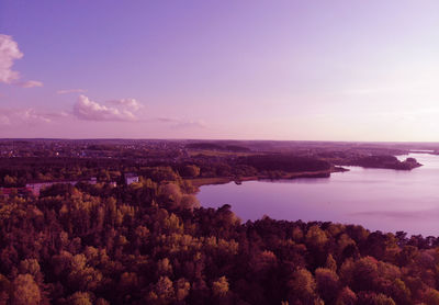 High angle view of townscape by sea against sky during sunset