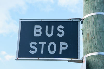 Close-up of road sign against sky