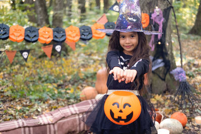 Halloween. cute arab girl in witch costume with jack o lantern outdoor