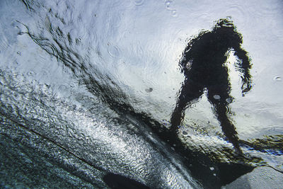 Underwater view of young man surfing in south male atoll