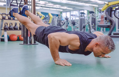 Full length of man exercising at gym