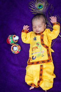 High angle view of cute baby boy holding toy on table