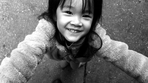 Close-up high angle portrait of cute smiling girl standing on footpath