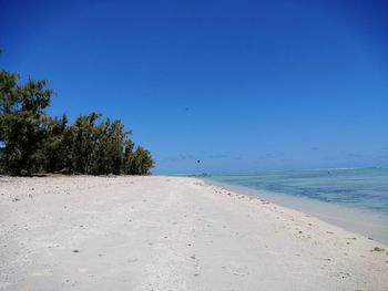 Scenic view of beach against clear blue sky