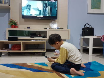 Boy sitting on table at home