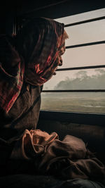 Side view of man with dog sitting on floor