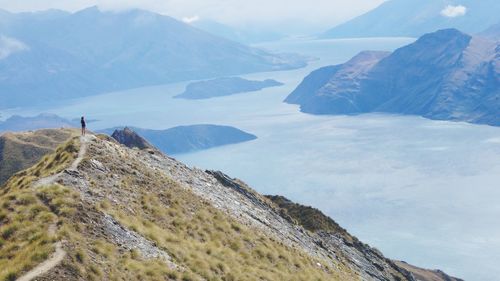 Person standing on mountain by river