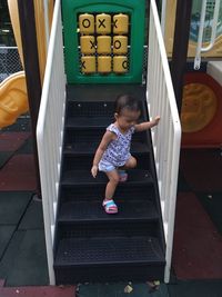 Full length of cute girl playing on staircase