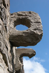 Low angle view of stone structure against blue sky