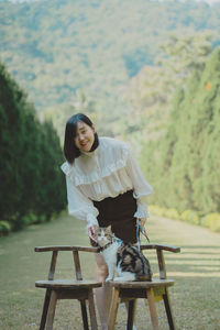 Side view of young woman sitting on bench
