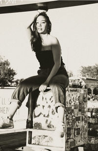 Low angle view of young woman standing against buildings