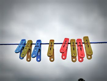 Low angle view of clothespins hanging on clothesline