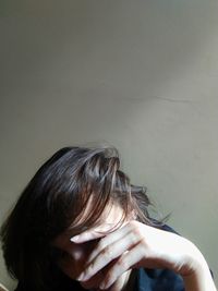 Portrait of woman against wall at home