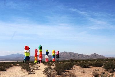 People standing on mountain against blue sky