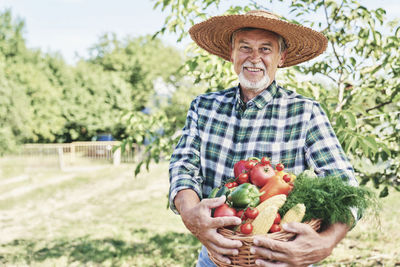 Portrait of smiling man holding fruits