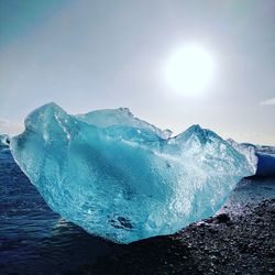 Scenic view of ice on mountain against sky during sunset