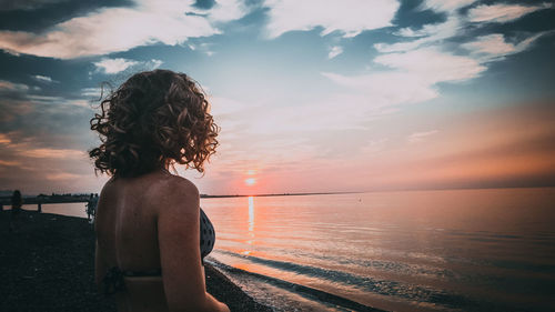 Rear view of woman looking at sea against sky