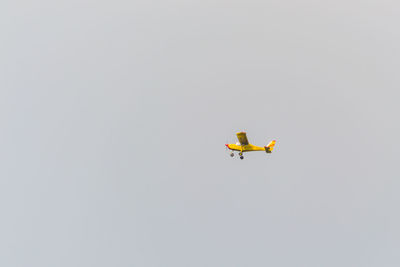 Low angle view of airplane flying against clear sky