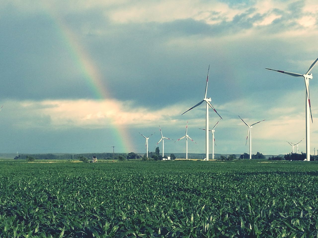 WINDMILL ON FIELD AGAINST CLOUDY SKY