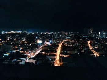 Illuminated cityscape against sky at night