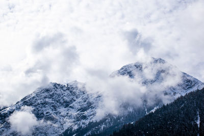 Low angle view of snowcapped mountains against sky