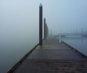 Bridge over river in city against sky