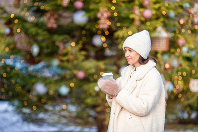 Portrait of woman standing against trees