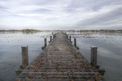 Pier over lake against sky