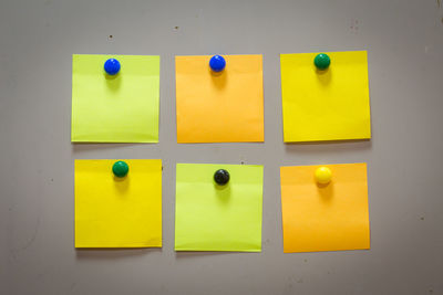 Close-up of yellow colored pencils on tiled wall