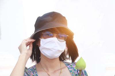 Portrait of young woman wearing sunglasses against sky