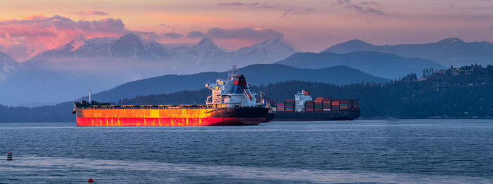 Ship in sea against sky during sunset