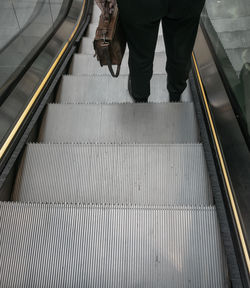 Low section of man standing on escalator