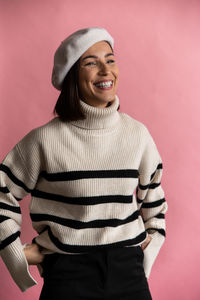 Portrait of woman standing against yellow background