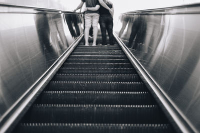 Rear view of woman standing on escalator