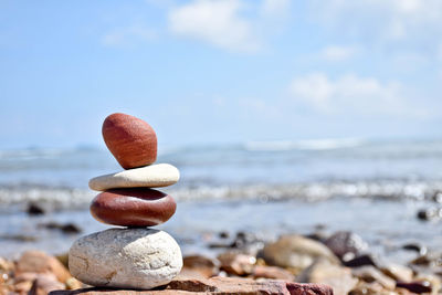 Close-up of pebbles on beach against sky