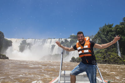 Young man posing in front of the iguacu waterfalls in argentina