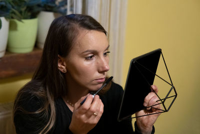 Young woman using mobile phone at home