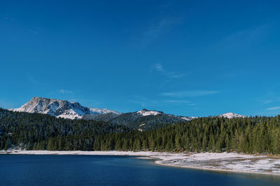 Scenic view of snowcapped mountains against blue sky