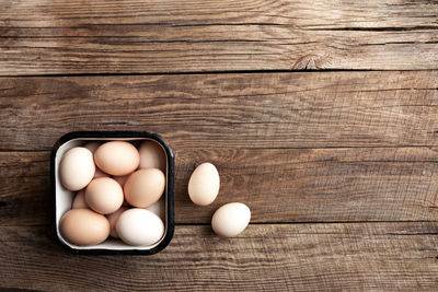 High angle view of metal container with eggs on wooden table