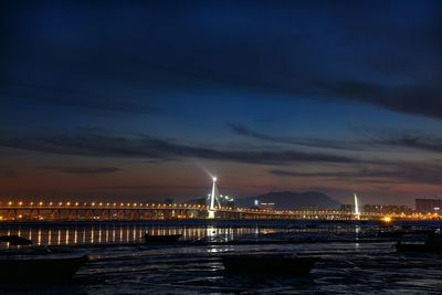 Bridge over sea against cloudy sky during sunset