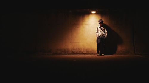 Rear view of man walking on footpath at night