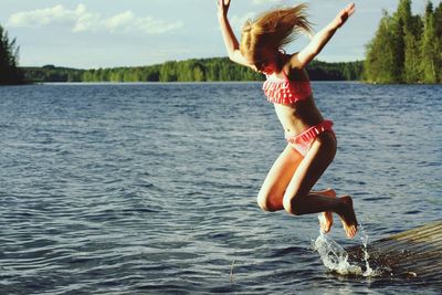 Bikini girl jumping in lake