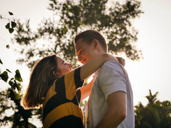 Couple standing by tree against plants