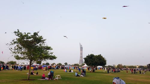 People with birds flying in sky