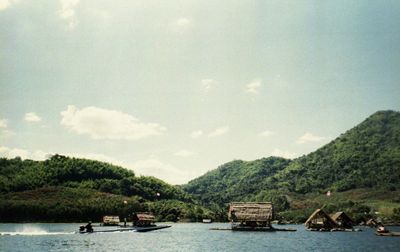 Boats in river against sky