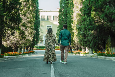 Rear view of couple walking on road