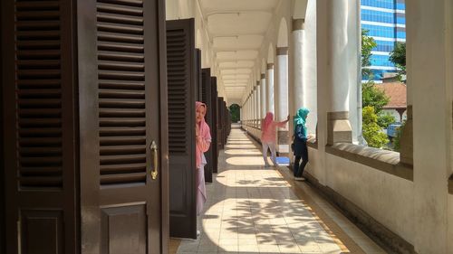 Rear view of man walking in corridor of building