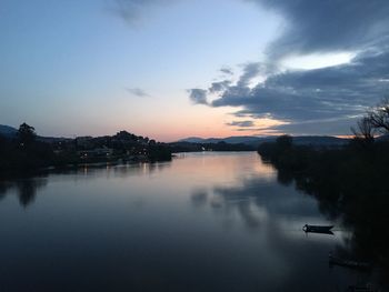 Scenic view of river against sky at dusk