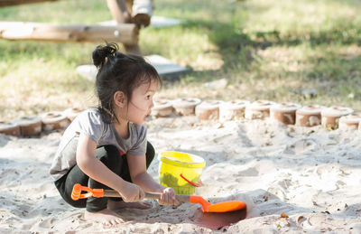 Girl playing on sand at park