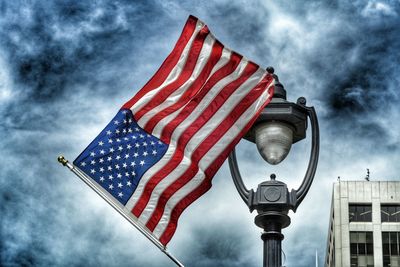 Low angle view of american flag against cloudy sky